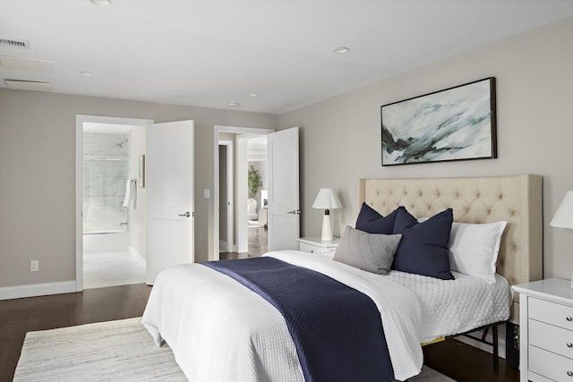 bedroom with ensuite bath and dark wood-type flooring