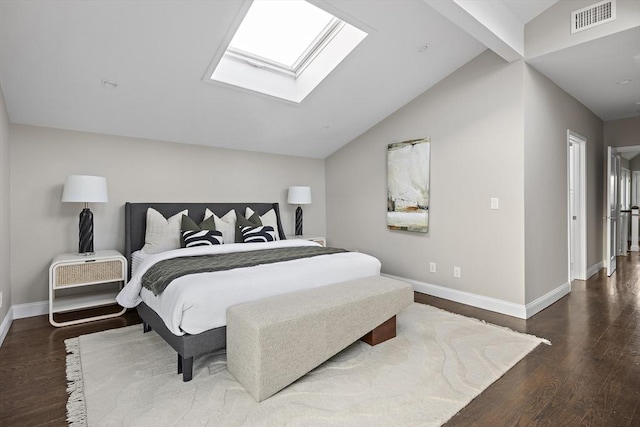 bedroom featuring lofted ceiling with skylight and dark hardwood / wood-style floors