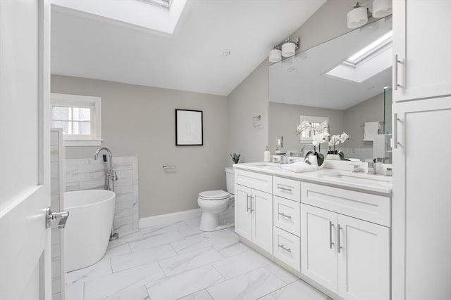 bathroom featuring toilet, vanity, a washtub, and lofted ceiling with skylight