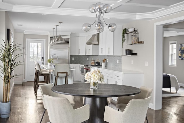 dining space featuring coffered ceiling, beamed ceiling, ornamental molding, dark hardwood / wood-style floors, and an inviting chandelier