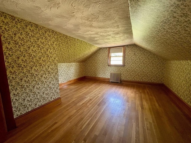 20 Birch St, Acushnet, MA 02743 - additional living space with radiator heating unit, wood finished floors, a textured ceiling, wallpapered walls, and vaulted ceiling