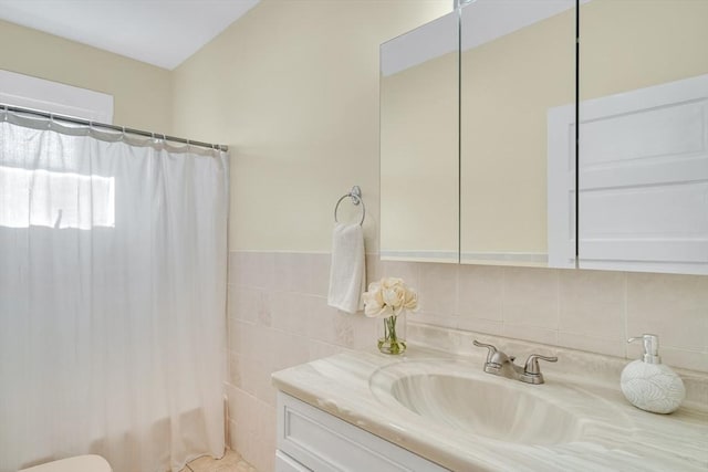 bathroom with vanity, shower / bath combination with curtain, and tile walls