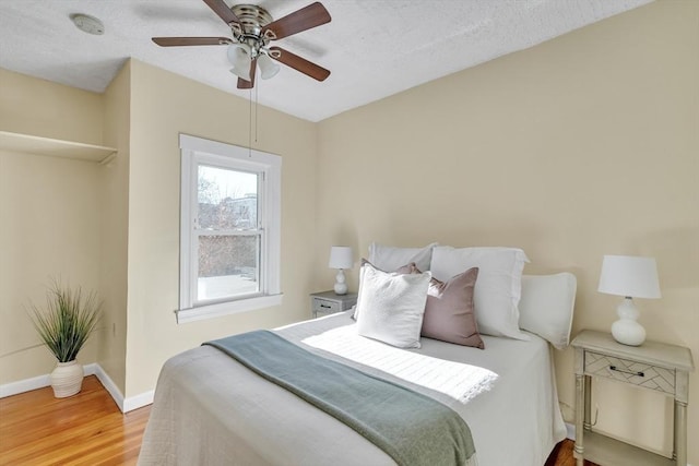 bedroom featuring ceiling fan, a textured ceiling, and hardwood / wood-style flooring