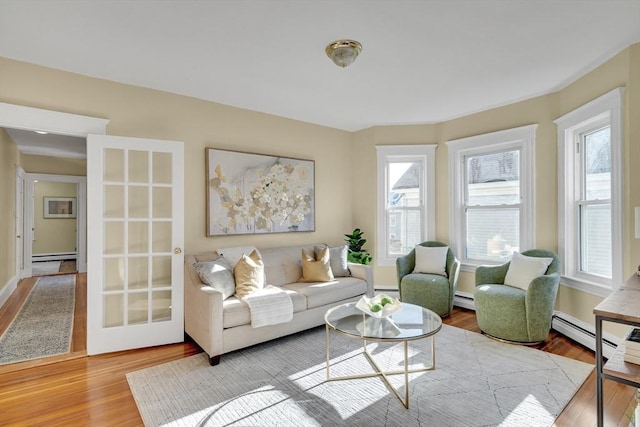 living room featuring light wood-type flooring and a baseboard heating unit