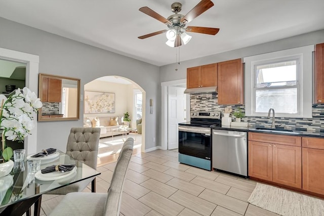 kitchen featuring decorative backsplash, appliances with stainless steel finishes, ceiling fan, and sink