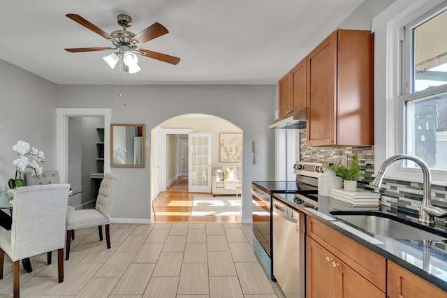 kitchen featuring ceiling fan, sink, stainless steel appliances, tasteful backsplash, and light wood-type flooring