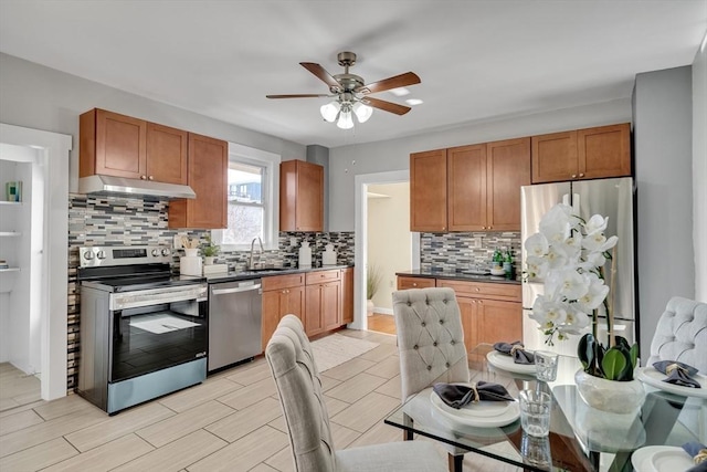 kitchen with sink, light hardwood / wood-style flooring, ceiling fan, tasteful backsplash, and stainless steel appliances