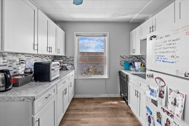 kitchen with white cabinetry, black dishwasher, wood finished floors, and freestanding refrigerator