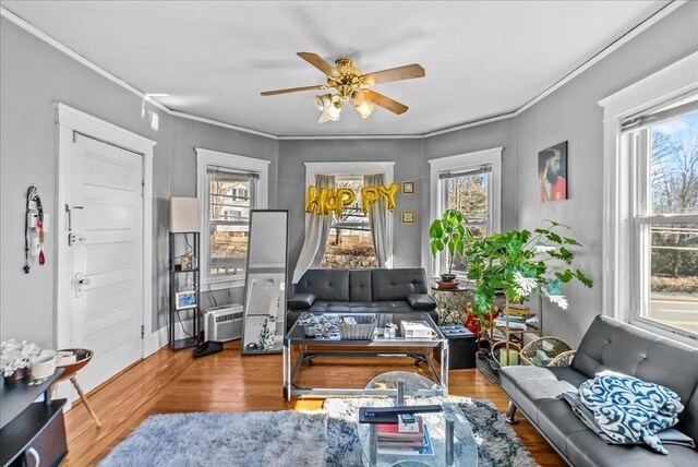 sitting room with crown molding, a ceiling fan, and wood finished floors
