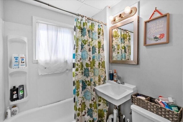 full bathroom featuring toilet and shower / bathtub combination with curtain