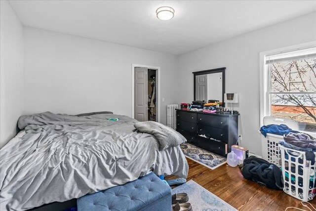 bedroom featuring radiator heating unit and wood finished floors