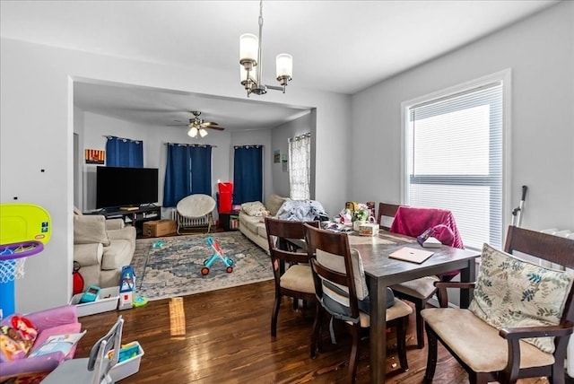 dining area with wood finished floors and ceiling fan with notable chandelier