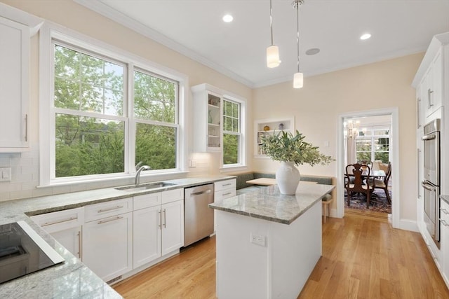 101 Waban St Unit 101, Newton, MA 02458 - kitchen with stainless steel appliances, a sink, a center island, tasteful backsplash, and crown molding