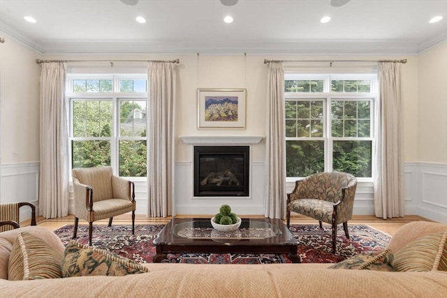 101 Waban St Unit 101, Newton, MA 02458 - living room with wainscoting, a glass covered fireplace, crown molding, wood finished floors, and a decorative wall