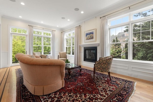 101 Waban St Unit 101, Newton, MA 02458 - living area with a decorative wall, ornamental molding, a glass covered fireplace, wood finished floors, and wainscoting