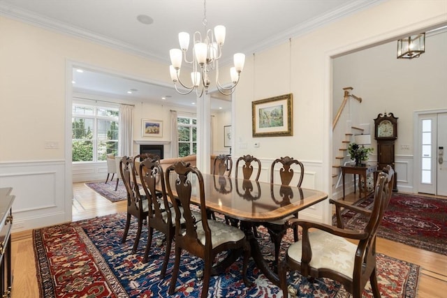 101 Waban St Unit 101, Newton, MA 02458 - dining room featuring a chandelier, a decorative wall, wainscoting, stairway, and crown molding