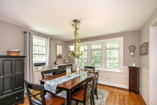 21 Flintlock Ridge Rd, Cohasset, MA 02025 - dining space with cooling unit, light wood-style flooring, a chandelier, and a wainscoted wall