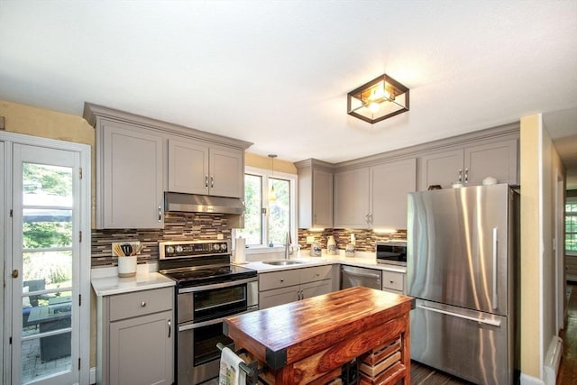 21 Flintlock Ridge Rd, Cohasset, MA 02025 - kitchen with gray cabinets, appliances with stainless steel finishes, under cabinet range hood, backsplash, and light countertops
