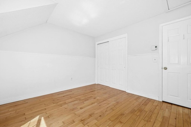 additional living space featuring light wood-type flooring and lofted ceiling