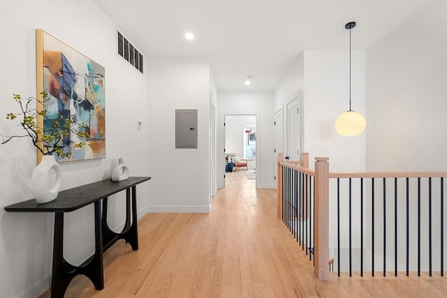 hall with light hardwood / wood-style floors and electric panel