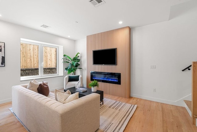 living room with light hardwood / wood-style flooring and a fireplace