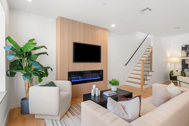 living room featuring a fireplace and light wood-type flooring