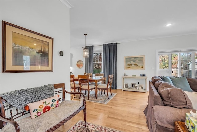 living room featuring light wood-style floors, ornamental molding, and recessed lighting