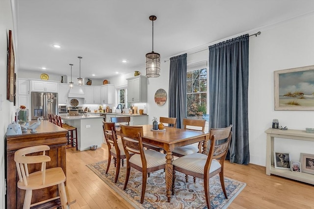 dining area featuring recessed lighting, light wood-style flooring, and a toaster