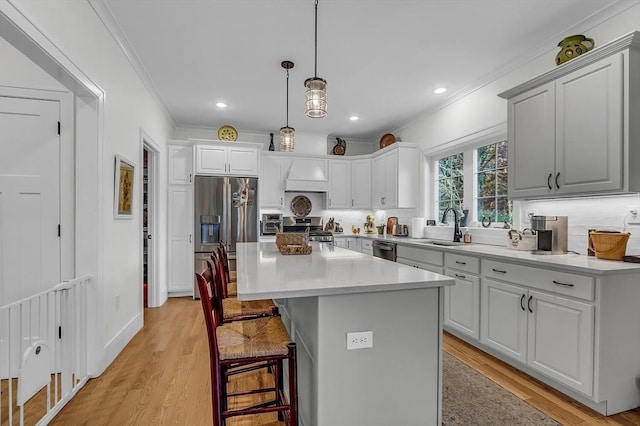 kitchen featuring crown molding, a sink, decorative backsplash, and appliances with stainless steel finishes