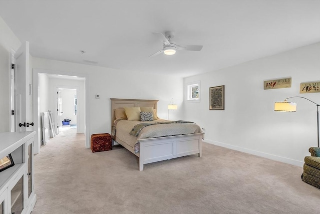 bedroom with a ceiling fan, baseboards, and light carpet