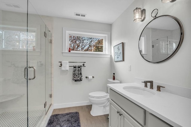 full bath with visible vents, a shower stall, wood finished floors, and vanity