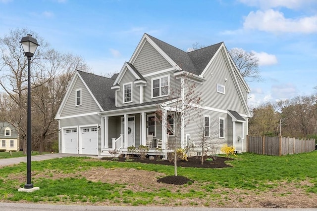 view of front of house featuring a porch, driveway, a front yard, fence, and an attached garage