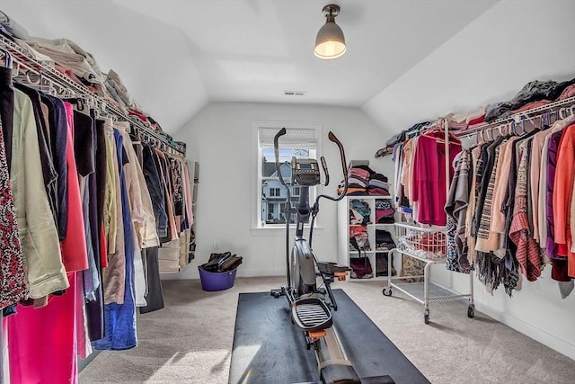 walk in closet featuring carpet floors, lofted ceiling, and visible vents