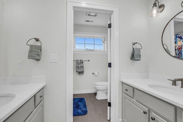 full bathroom featuring vanity, toilet, and visible vents
