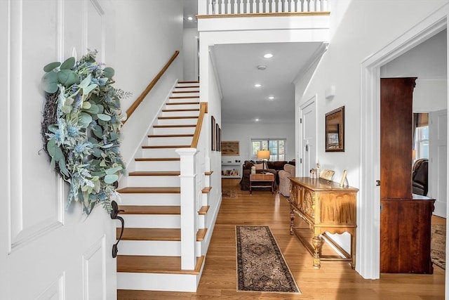 foyer entrance with recessed lighting, wood finished floors, and stairway