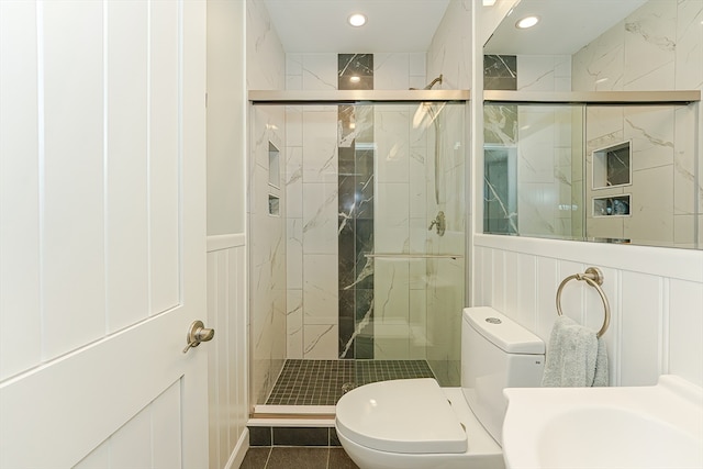 bathroom with a shower with door, tile patterned flooring, and toilet