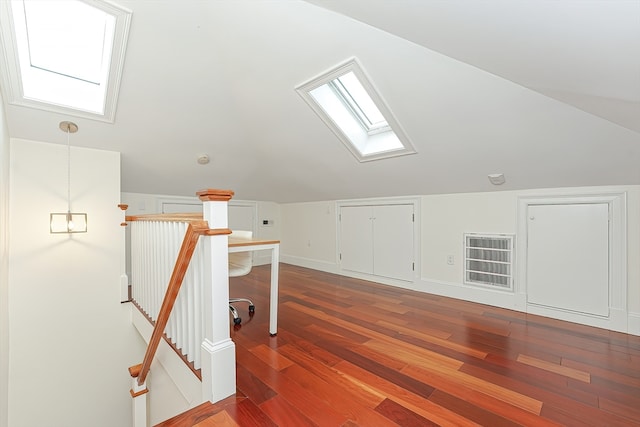 additional living space with wood-type flooring and vaulted ceiling with skylight