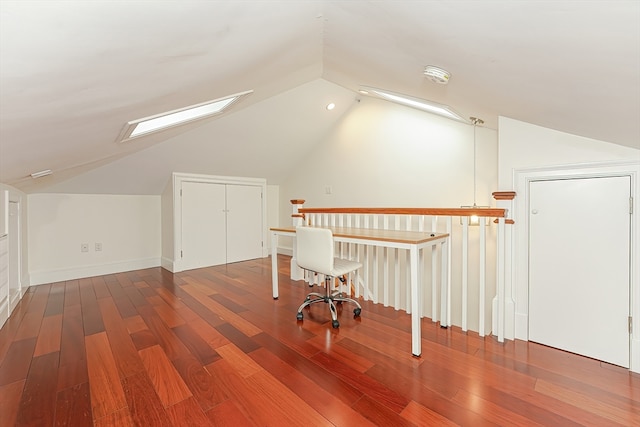 additional living space with lofted ceiling with skylight and wood-type flooring