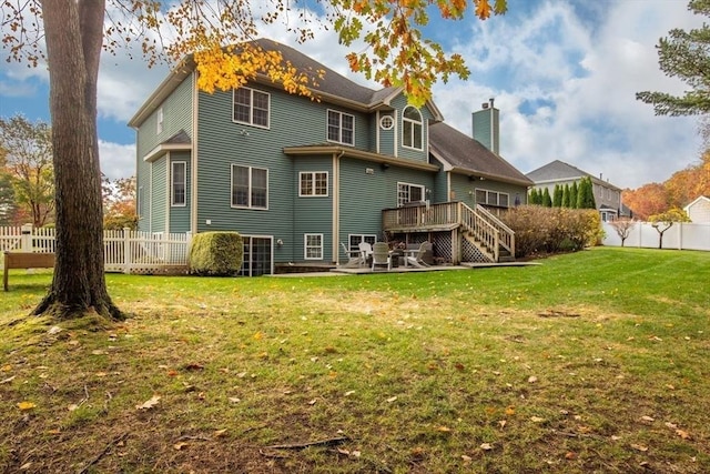 rear view of property with a yard and a deck