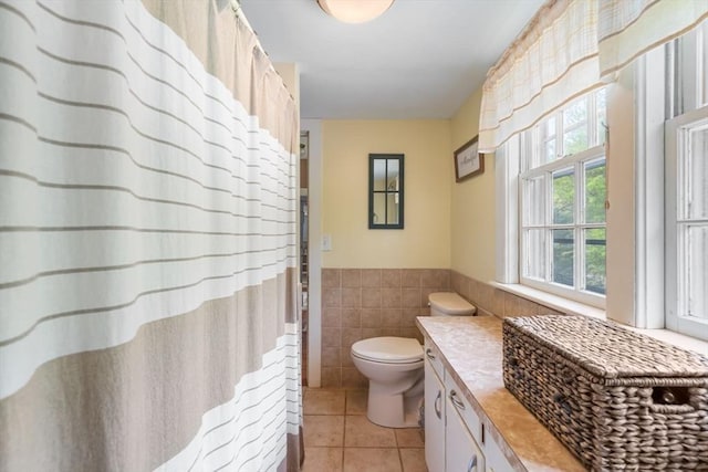 bathroom featuring vanity, tile walls, tile patterned floors, and toilet