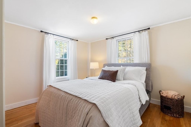 bedroom with ornamental molding and hardwood / wood-style floors