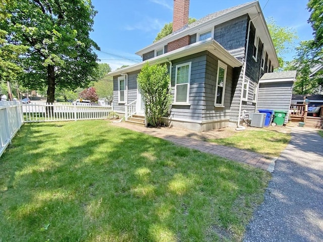 rear view of property with a chimney, central AC unit, and entry steps