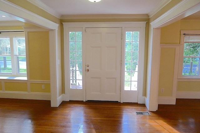 entryway with hardwood / wood-style floors, healthy amount of natural light, ornamental molding, and baseboards