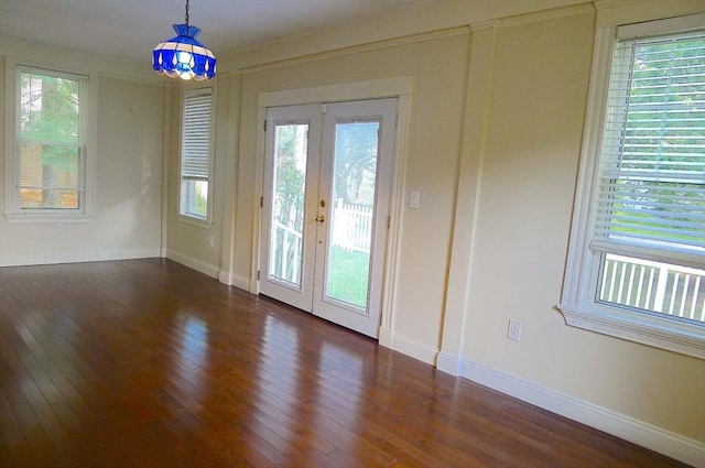 spare room featuring french doors, dark wood-style floors, and baseboards