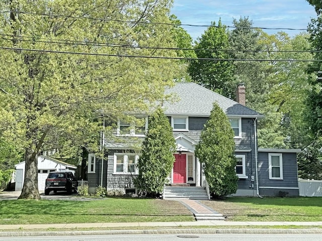 view of front of house with a chimney, an outbuilding, and roof with shingles