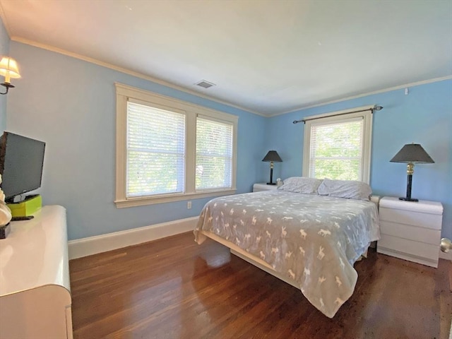 bedroom with wood finished floors, baseboards, and crown molding