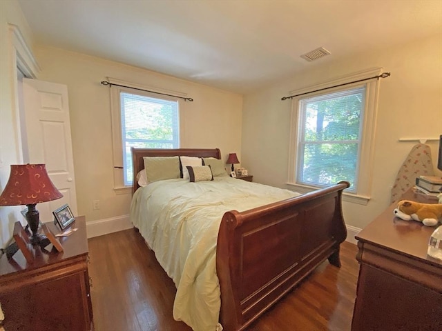bedroom featuring dark wood finished floors and baseboards