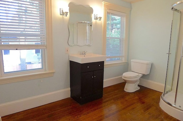 full bath with a shower stall, wood finished floors, baseboards, toilet, and vanity
