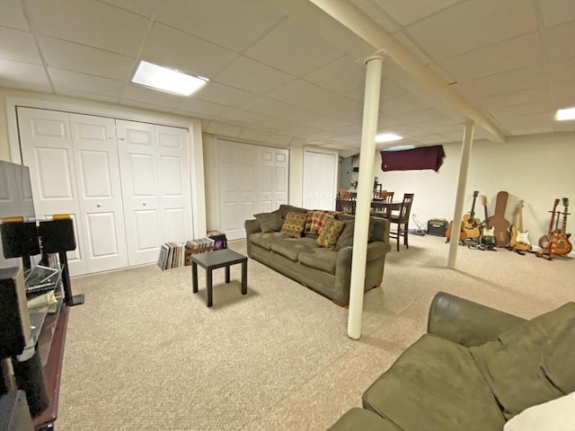 carpeted living room featuring a drop ceiling