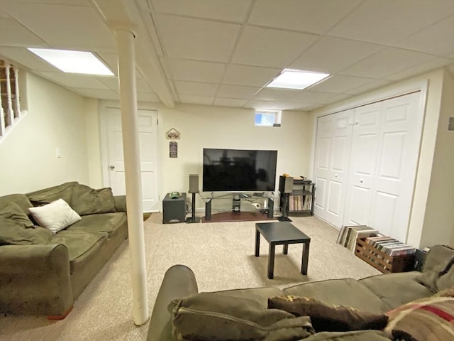 carpeted living room with a drop ceiling